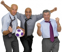 Three men in dress clothes with a soccer ball who are very excited about the Corporate Programs at the YMCA.