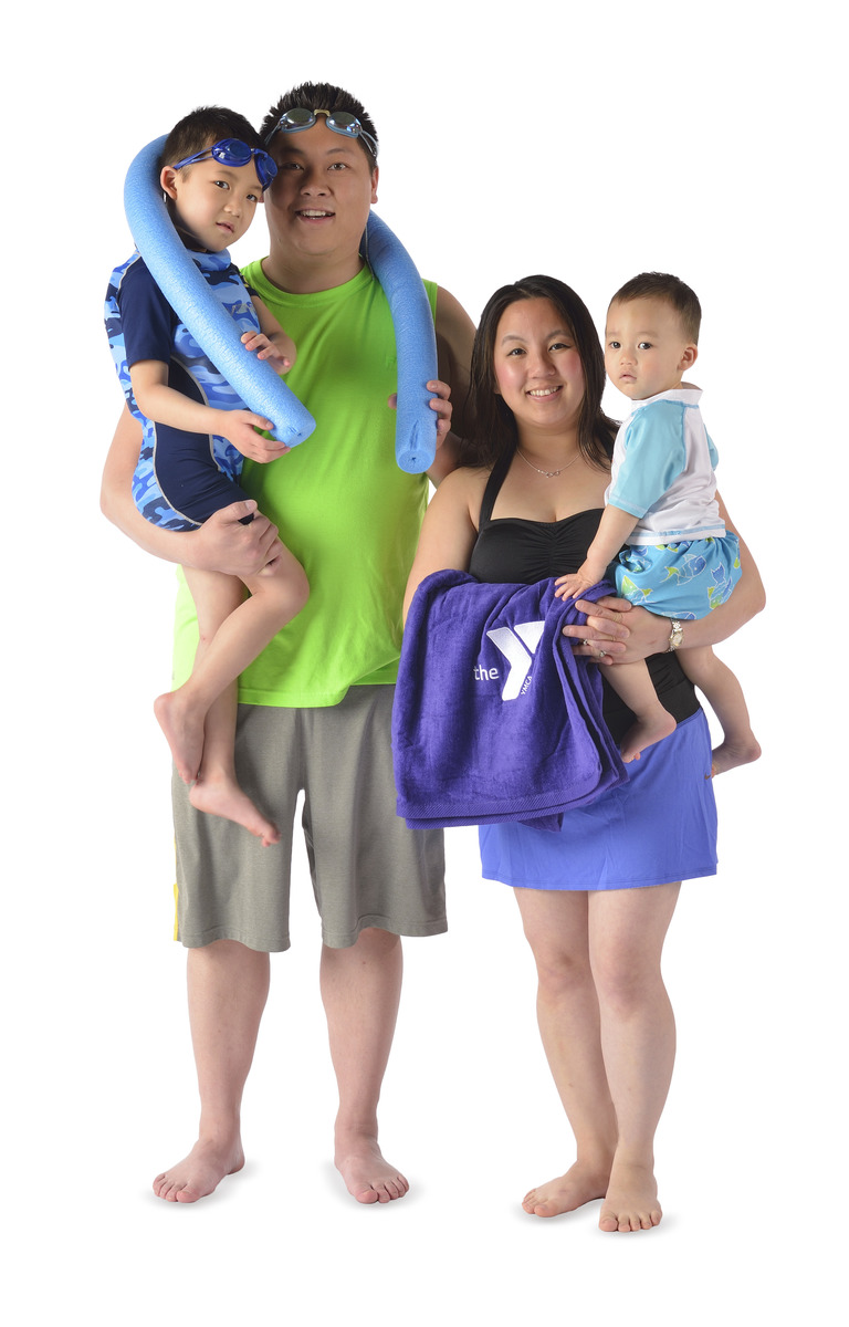 Family of four wearing swim gear.