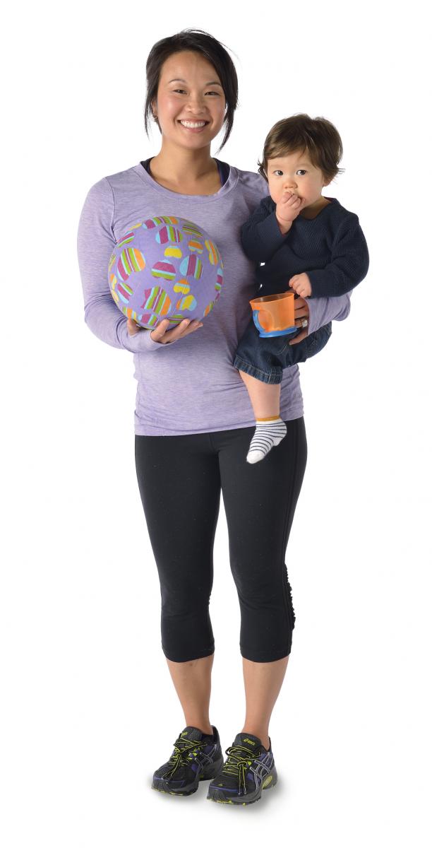 Woman holding soccer ball and child.