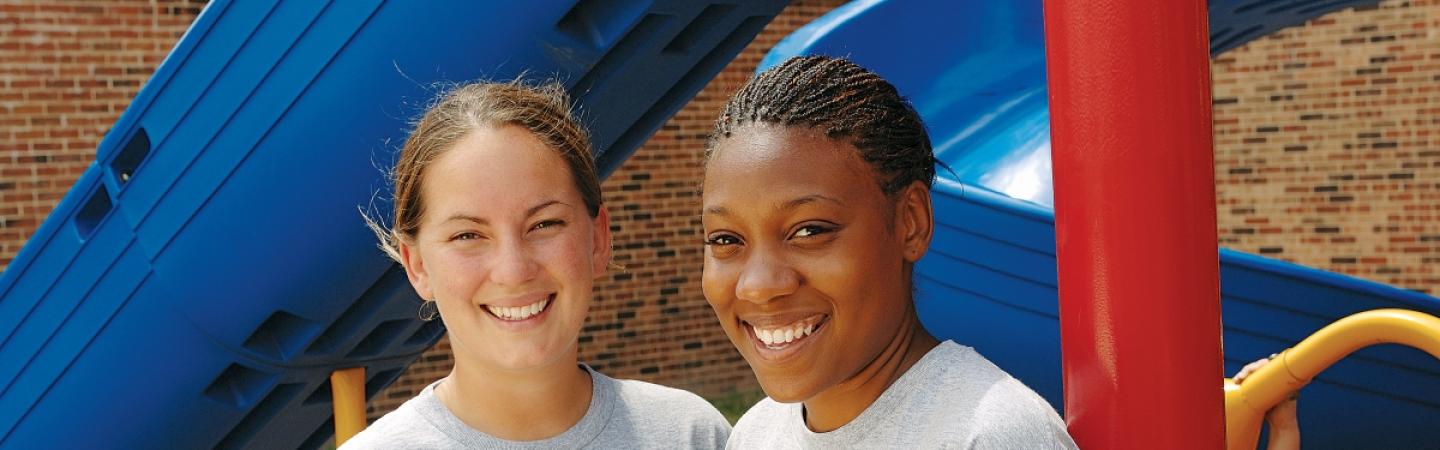 Two girls in front of slide.