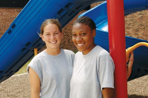 Two girls in front of slide. 