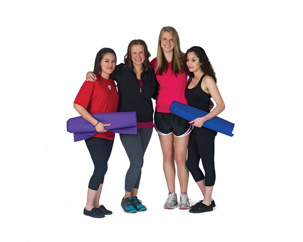 Four girls with rolled up workout mats. 